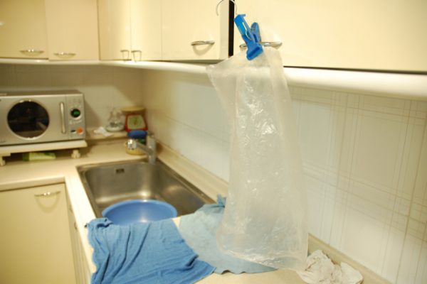 A plastic bag hangs above a sink after being washed.